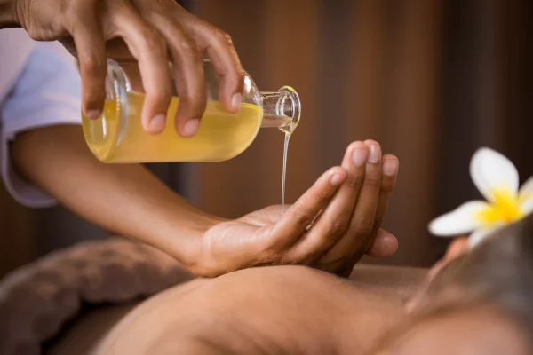 therapist-pouring-massage-oil-at-spa-2021-08-26-15-34-42-utc